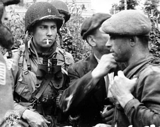 Membros da Resistência francesa e soldados da 82.ª Divisão Aerotransportada dos EUA a discutir a situação durante a Batalha da Normandia em 1944