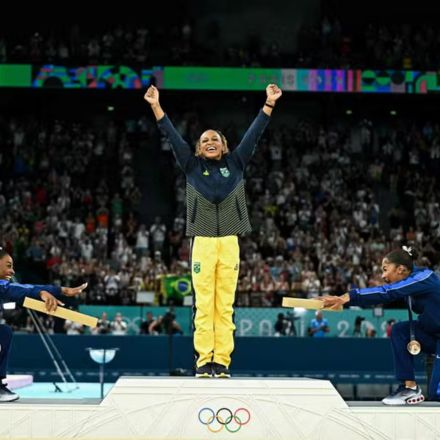 Ouro, Rebeca Andrade é reverenciada por Simone Biles e Jordan Chiles, que também subiram no pódio — Foto: Gabriel BOUYS / AFP